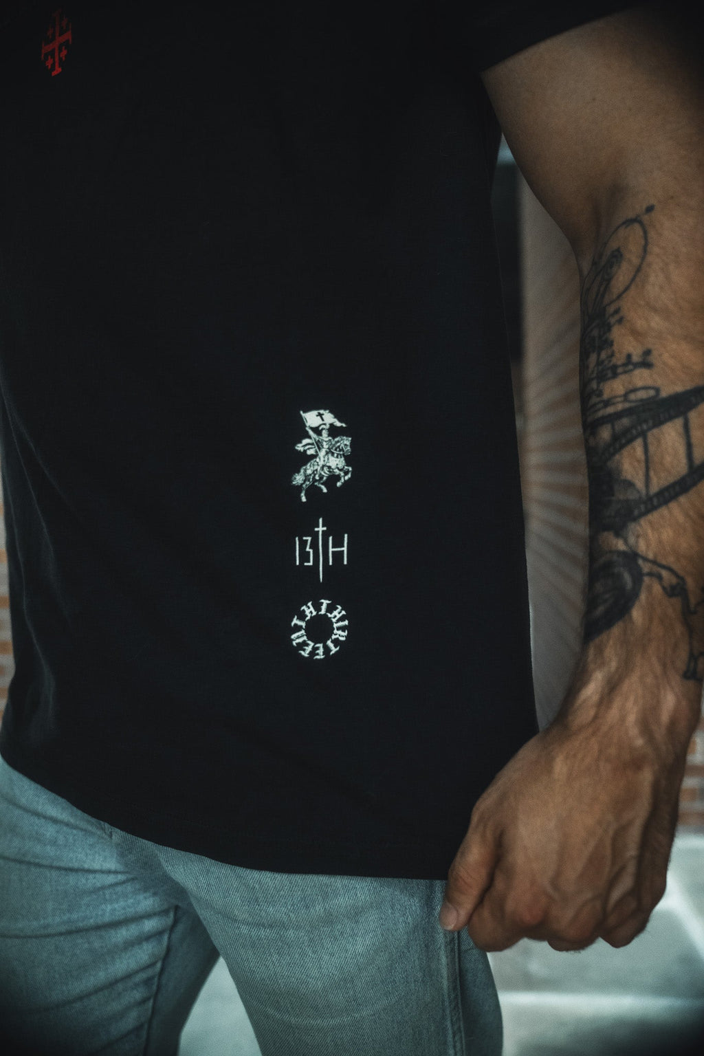 Black tee with small centered back emblem print near hem, crew neck