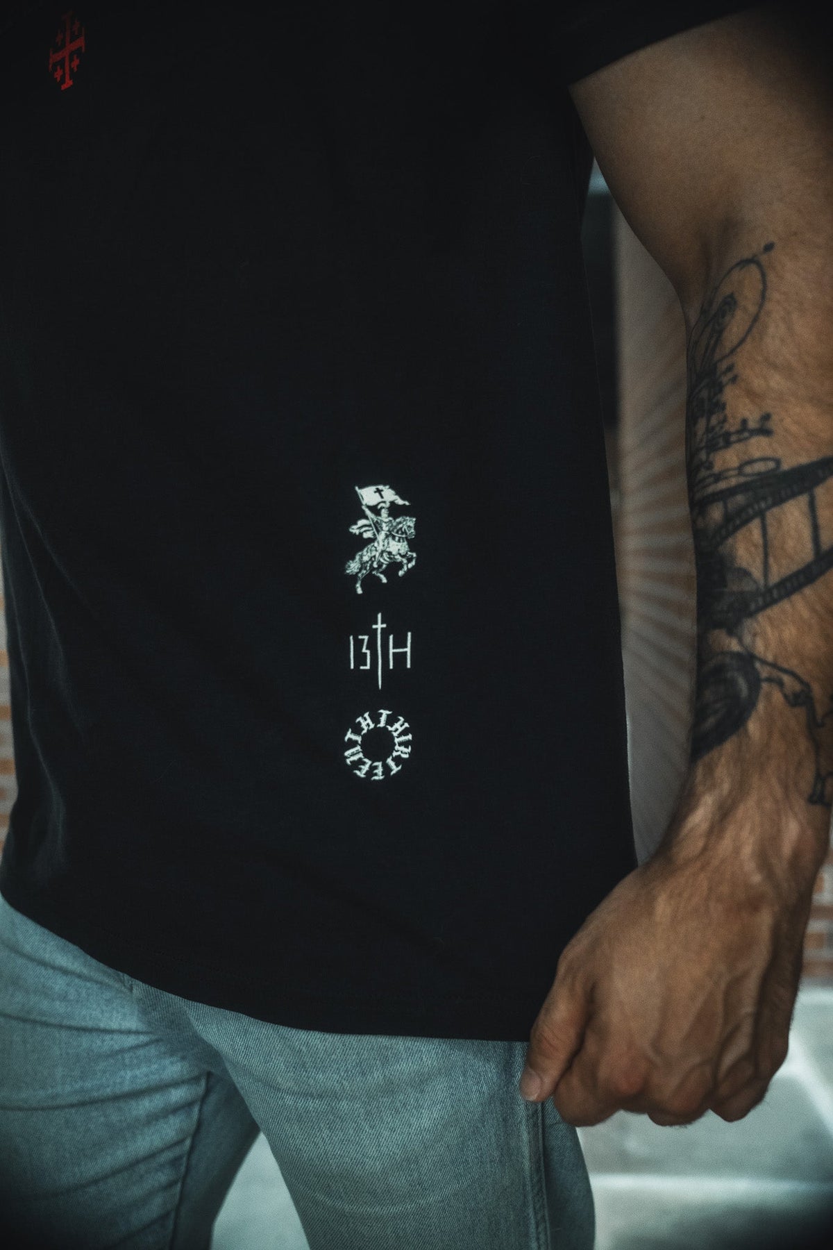 Black tee with small centered back emblem print near hem, crew neck