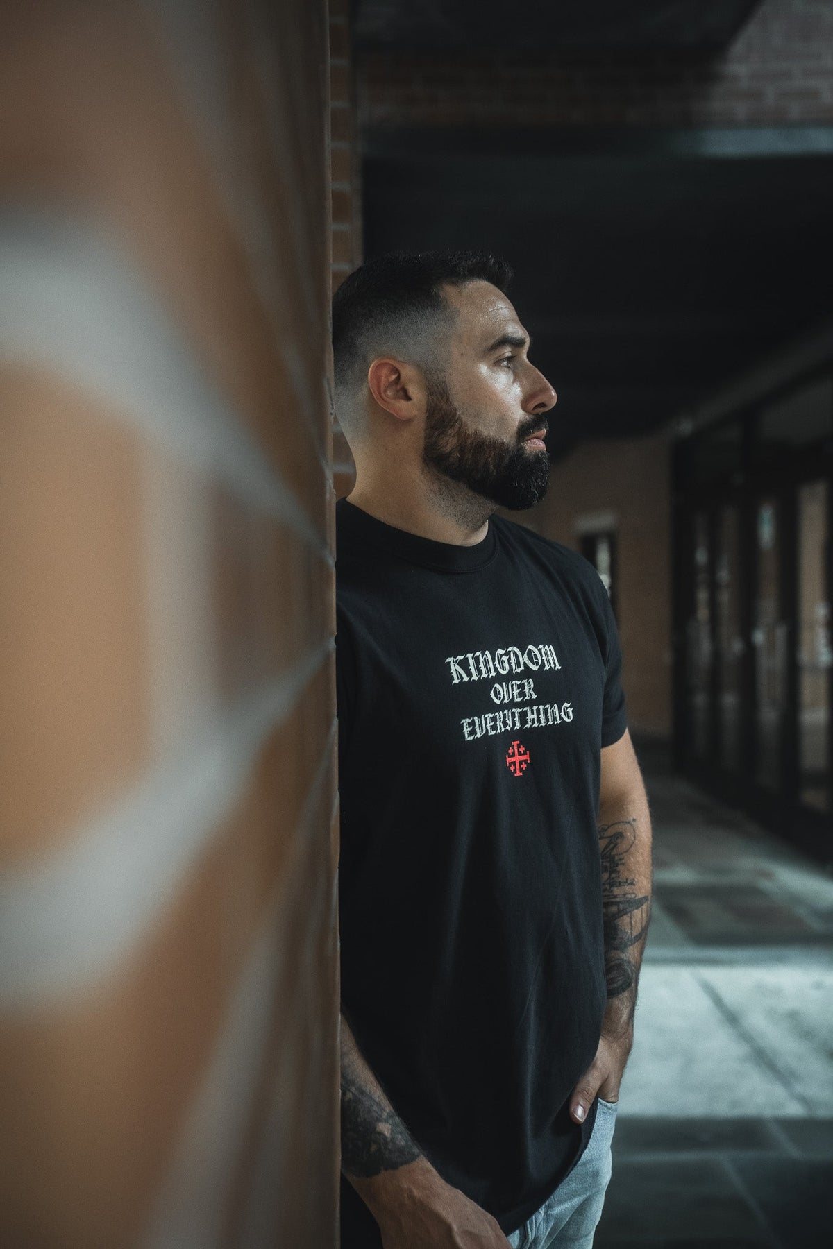 Black premium graphic tee with chest logo print, crew neck, short sleeves.