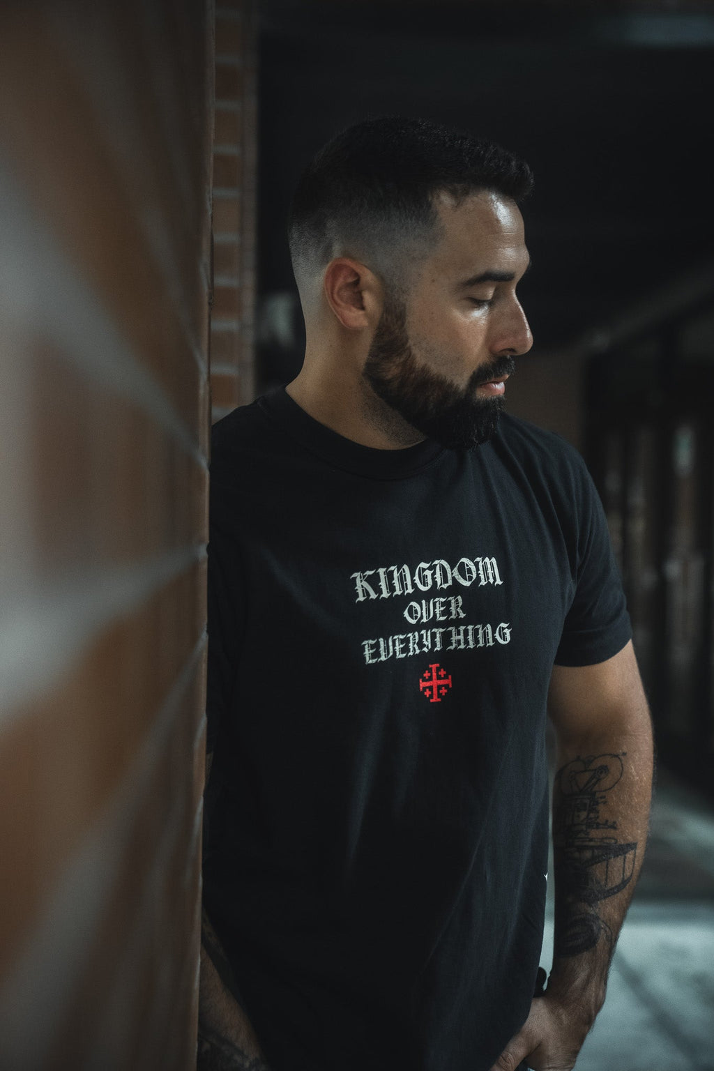 Black premium graphic tee with small chest logo print, crew neck, short sleeves.