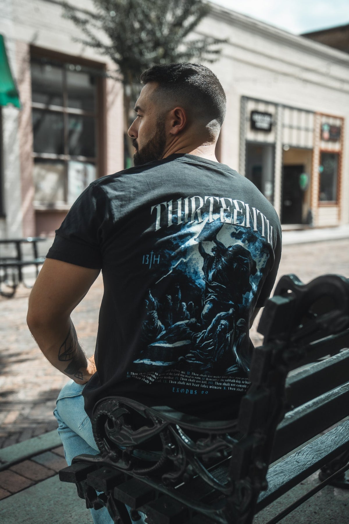 Black premium T-shirt with large blue back print and THIRTEENTH text on model
