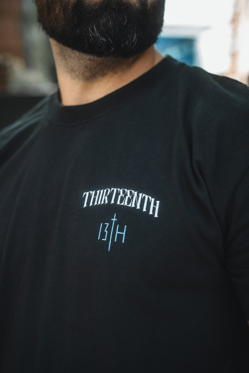 Black crewneck T-shirt with small white THIRTEENTH and 13TH chest print