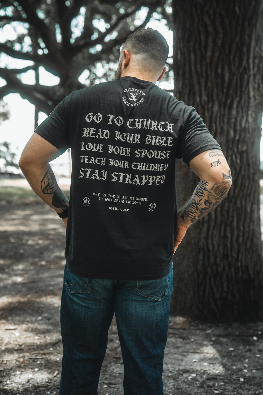 Black T-shirt back view with scripture-style lettering: Go to Church, Stay Strapped.