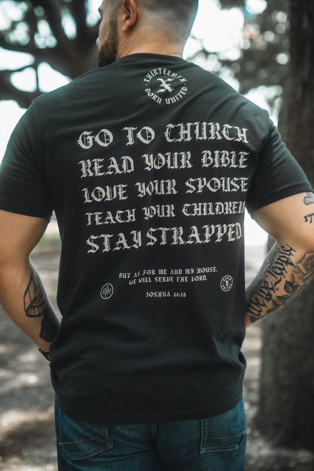 Black T-shirt back close-up with bold text: Go to Church, Read Your Bible, Stay Strapped.
