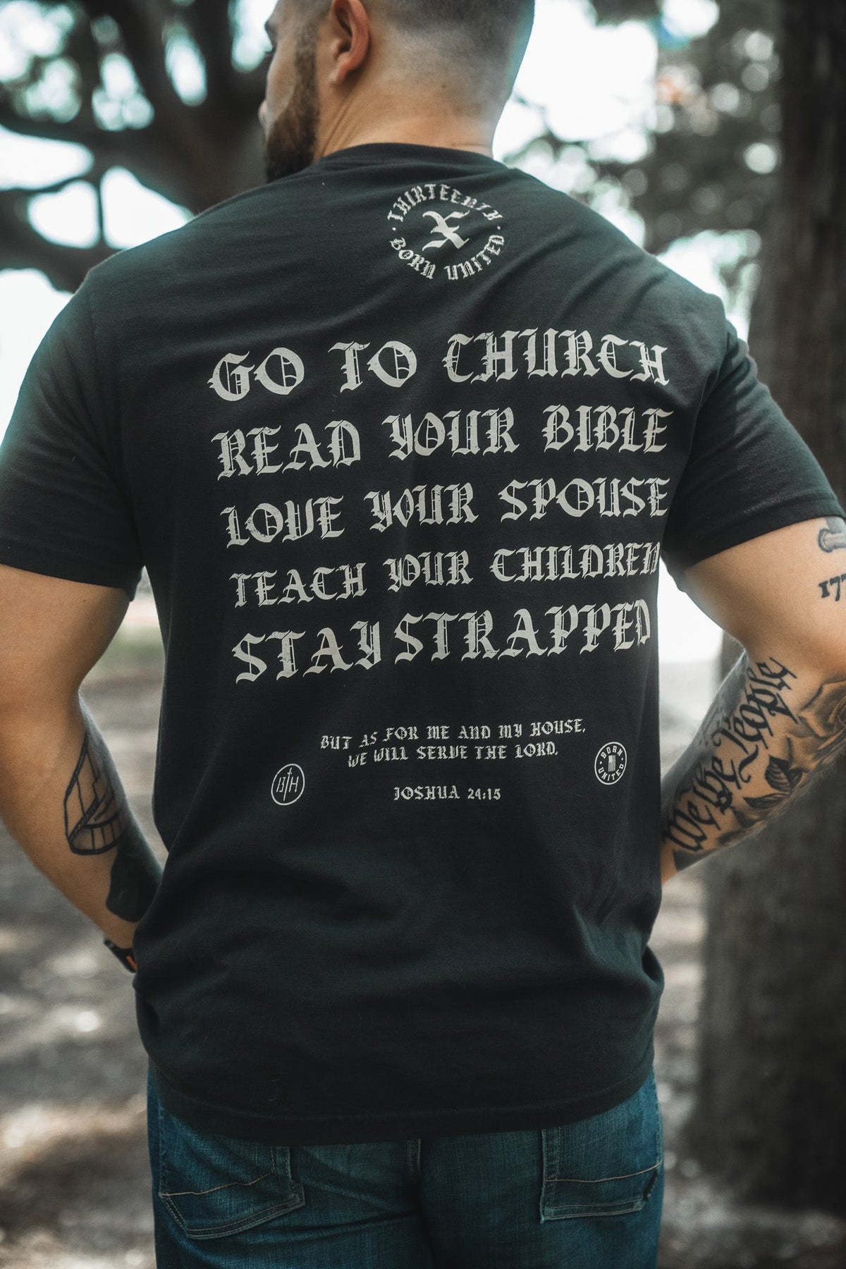 Black T-shirt back close-up with bold text: Go to Church, Read Your Bible, Stay Strapped.