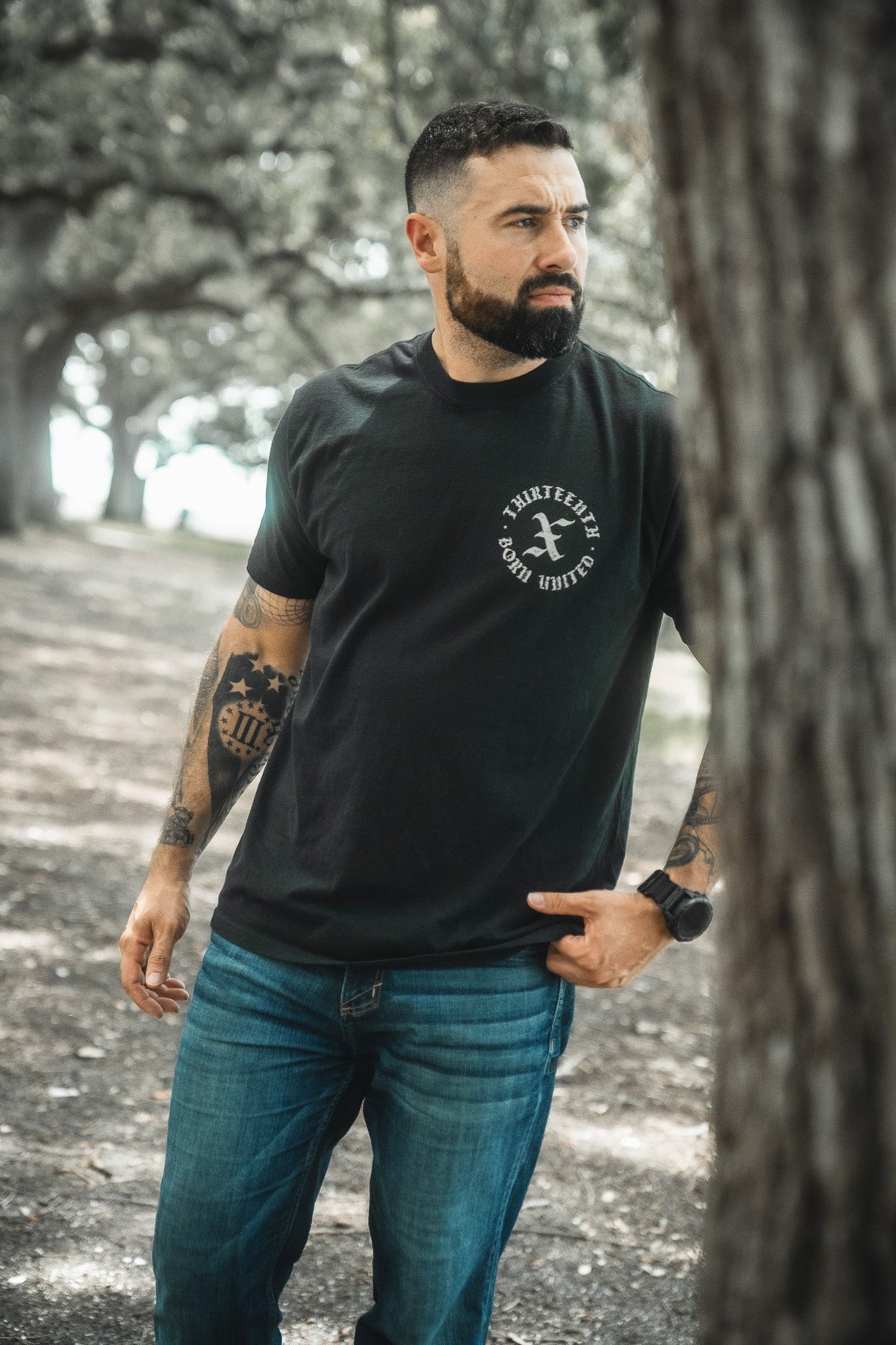 Black crewneck T-shirt with round chest logo graphic on the front