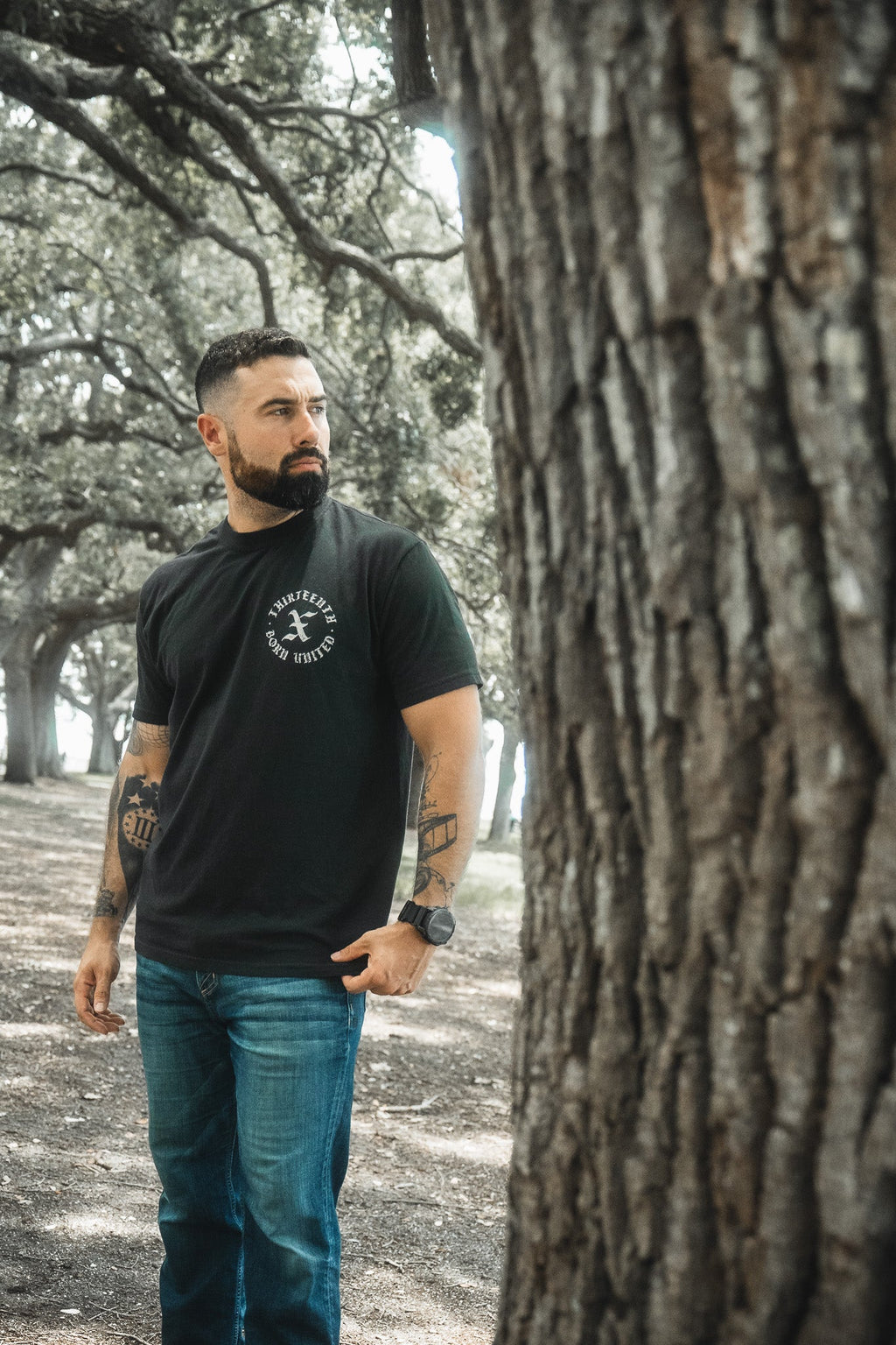 Black crewneck T-shirt with round chest logo graphic, short sleeves