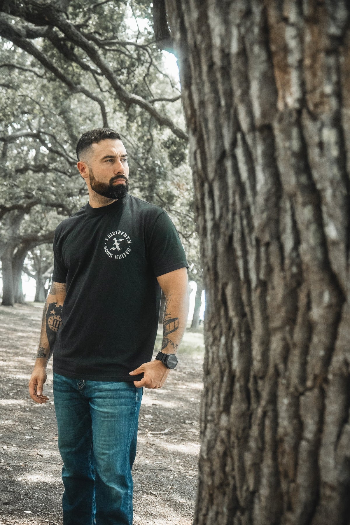 Black crewneck T-shirt with round chest logo graphic, short sleeves