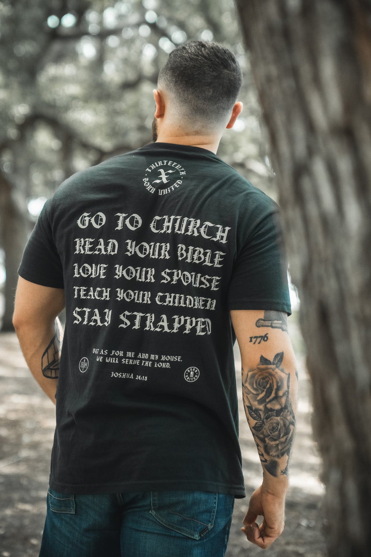 Black T-shirt back with full slogan and emblem above; short sleeves, crew neck.