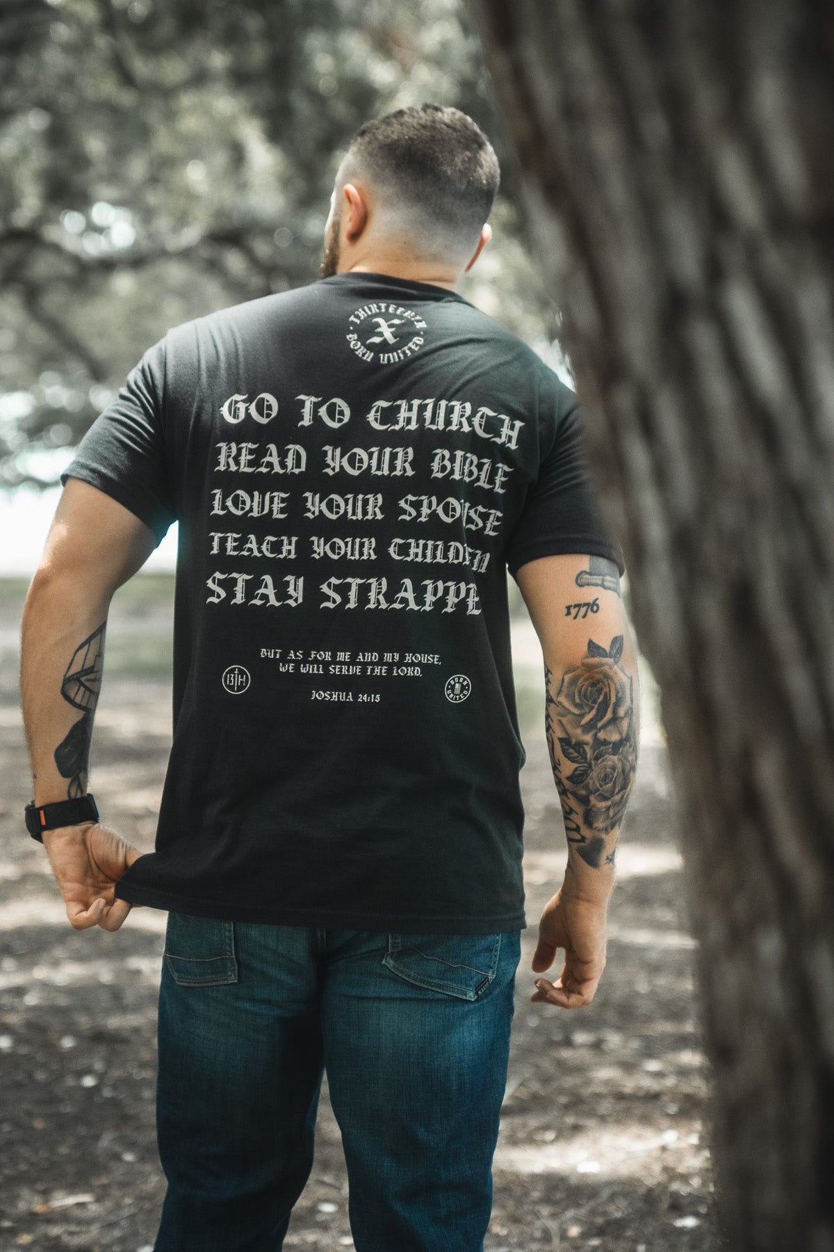 Black crewneck T-shirt with large back text graphic and small seal at bottom