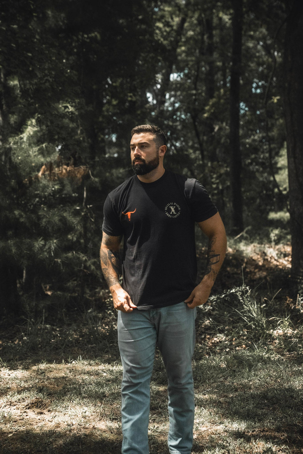Black graphic tee with orange bull logo and round chest emblem, short sleeves