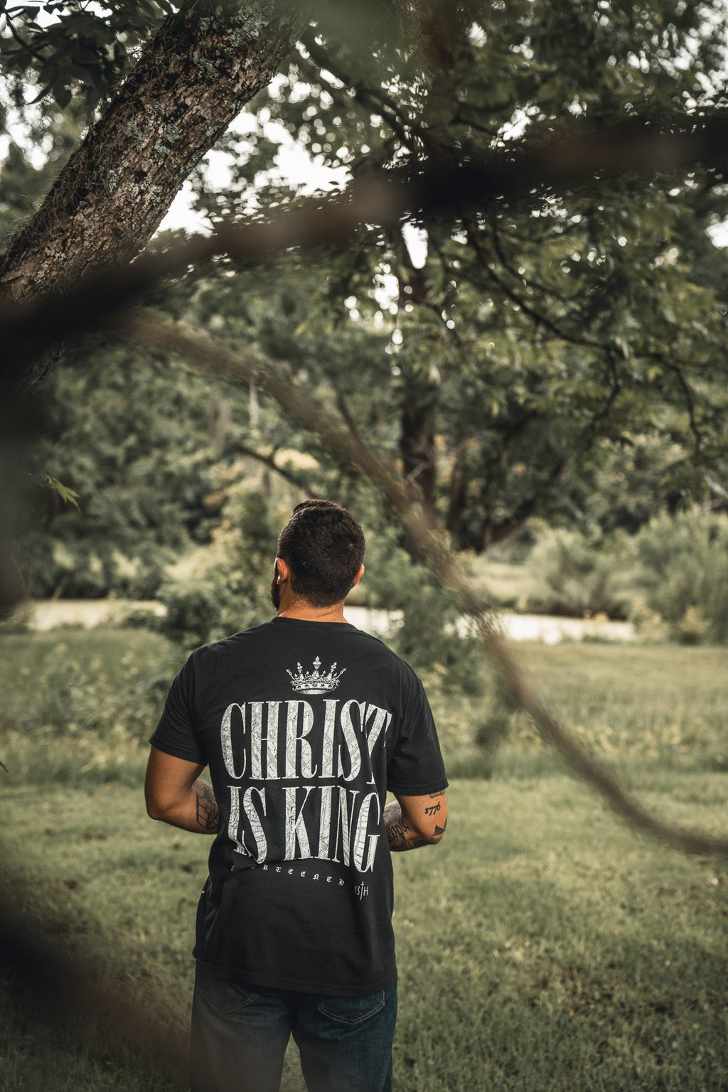Black T-shirt back with large "CHRIST IS KING" print and crown