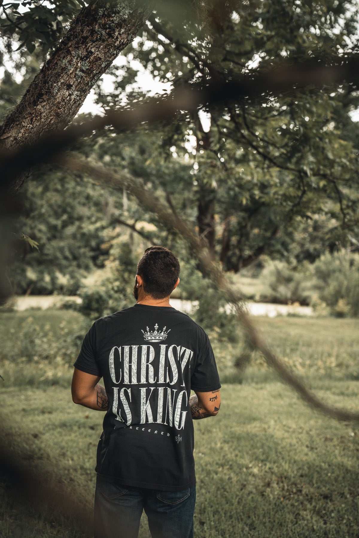 Black T-shirt back with large "CHRIST IS KING" print and crown