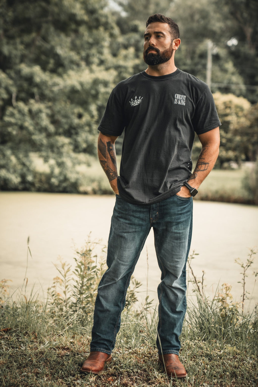 Black T-shirt front with small crown emblem and "CHRIST IS KING" graphic