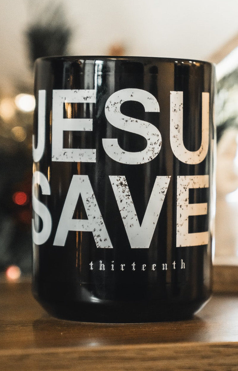Black ceramic mug with large 'JESUS SAVES' lettering and 'thirteenth' text
