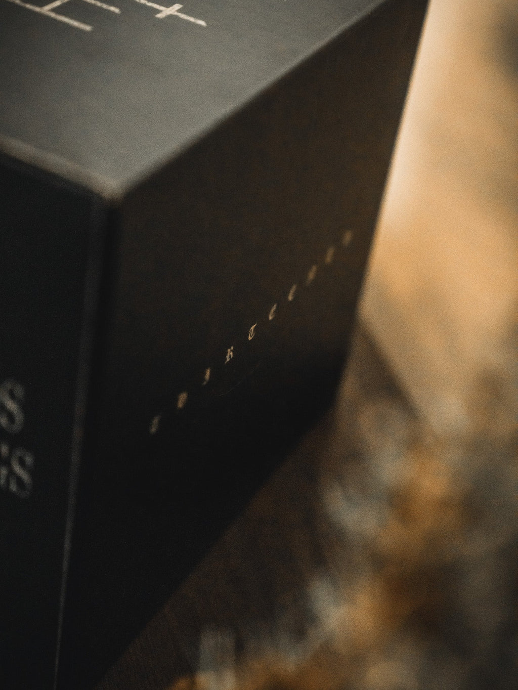 Black gift box with small gold lettering on the side