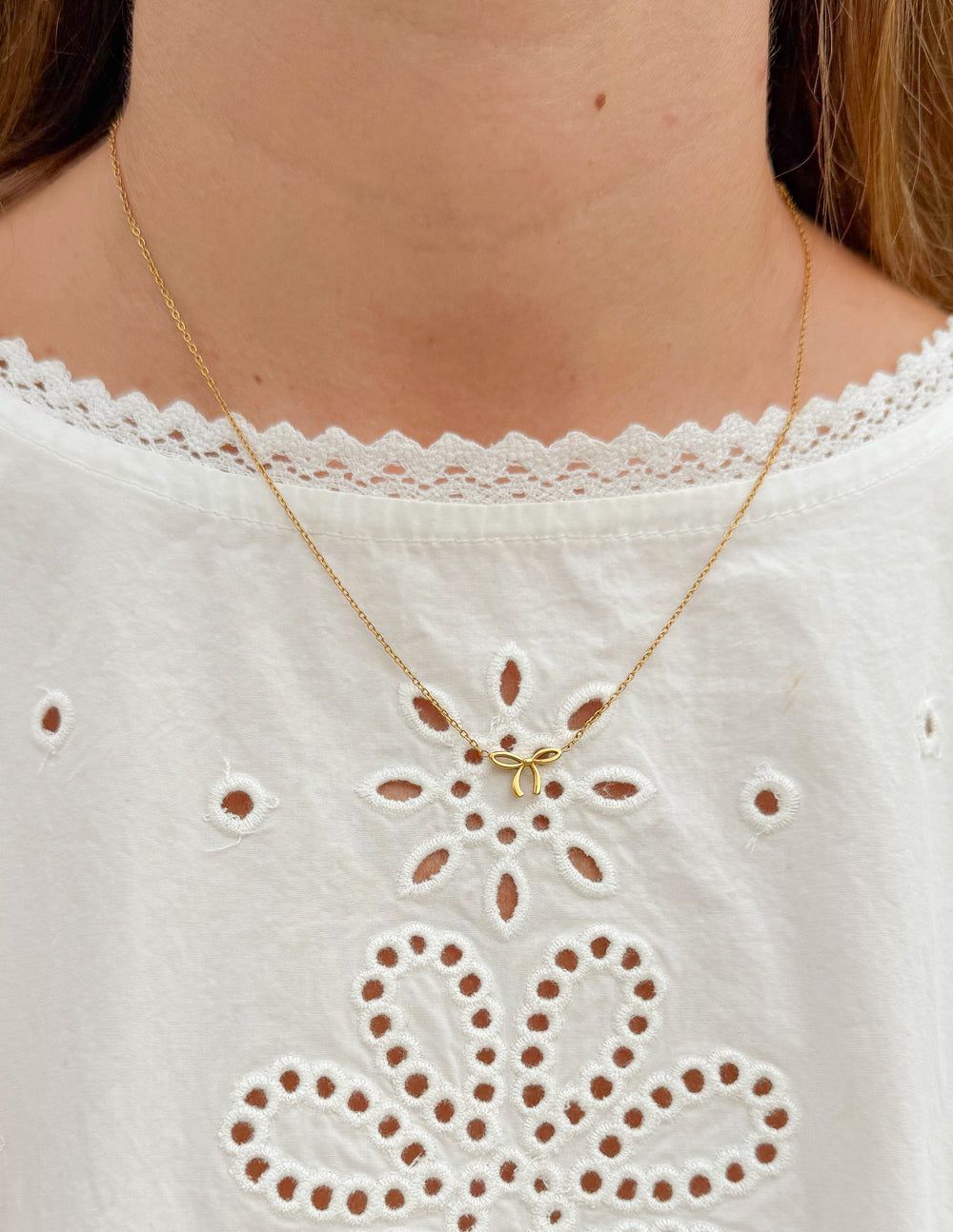 Gold bow pendant necklace with openwork bow design and fine chain