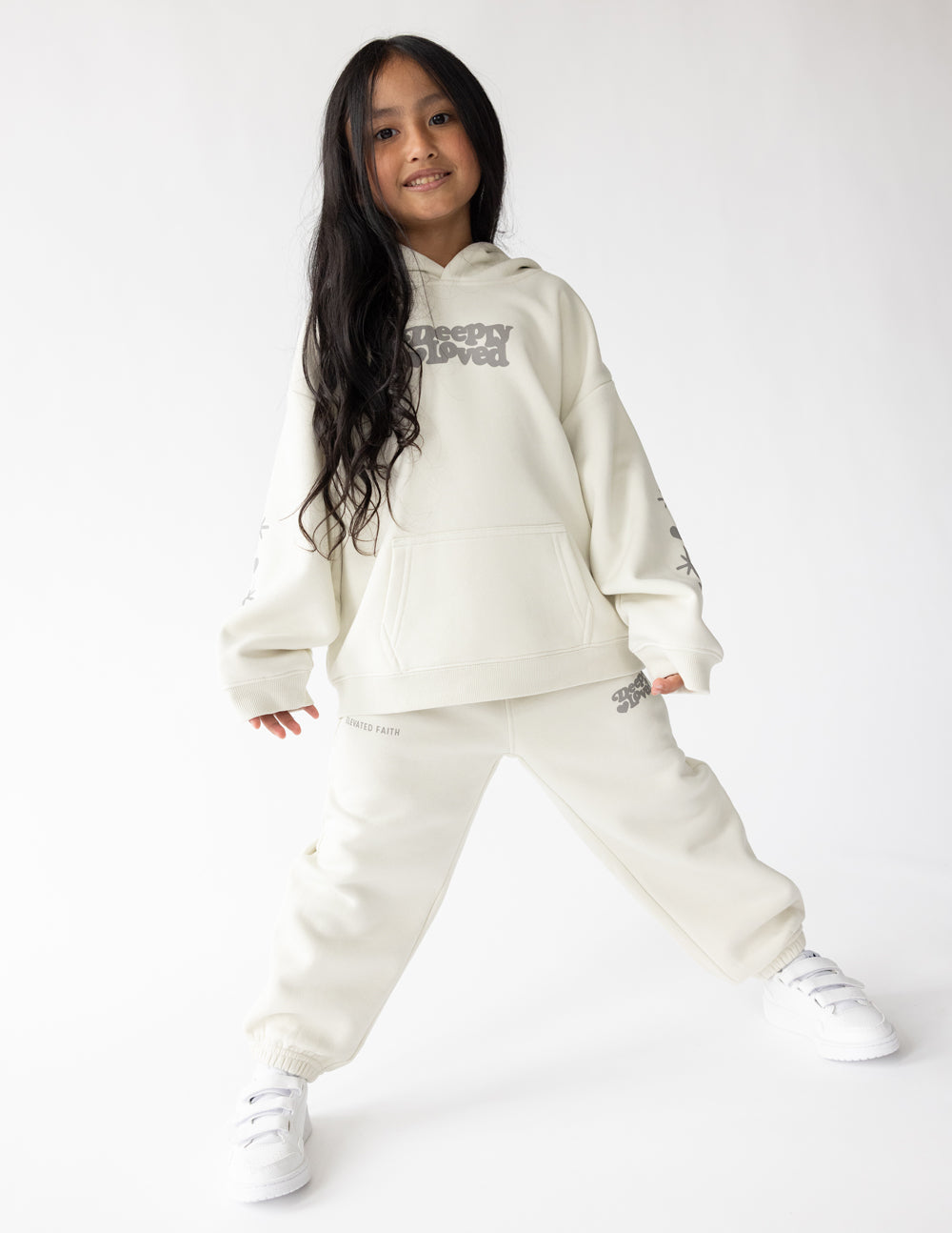 Kids hoodie off-white with hood and “Sleepy Loved” logo, worn with matching joggers