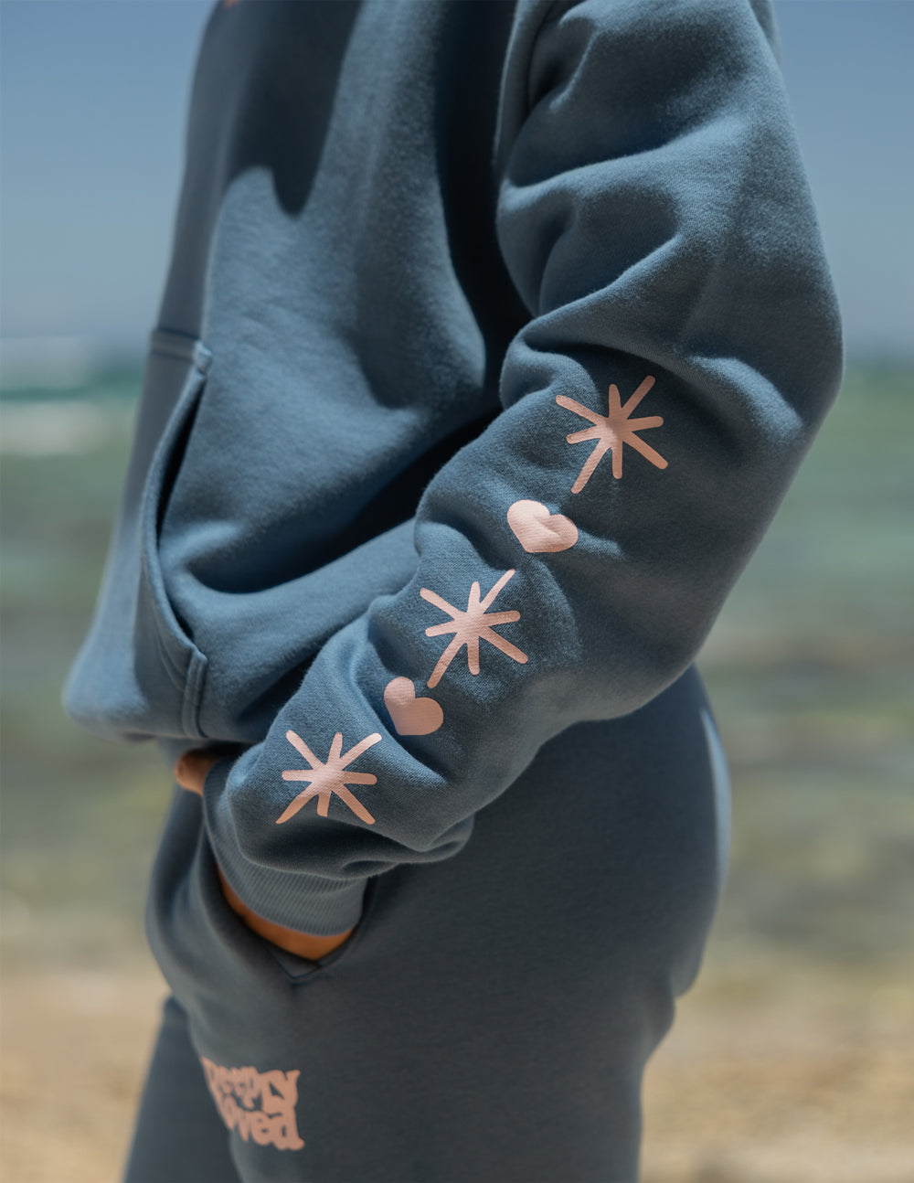 Blue hoodie sleeve cuff with white starburst prints and stitched hem detail