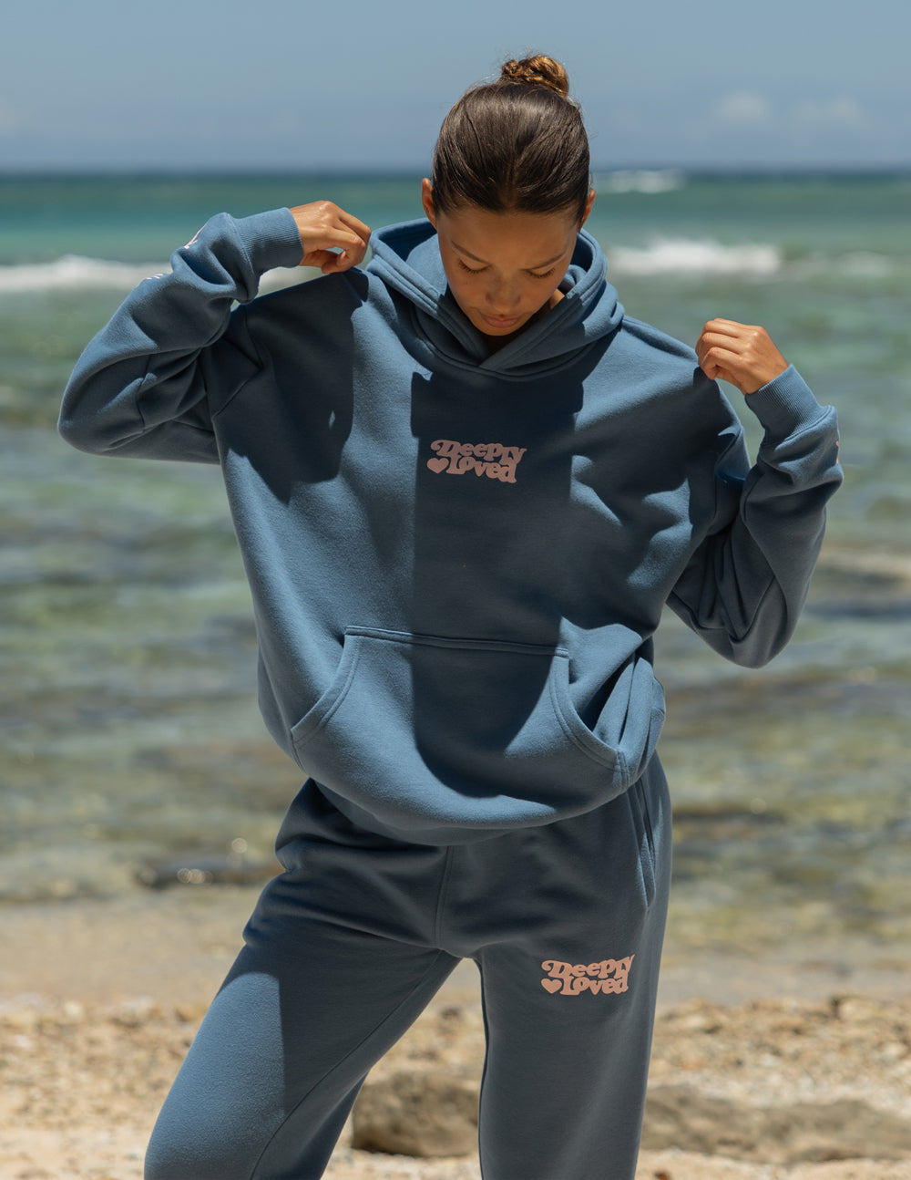 Blue unisex hoodie with hood, kangaroo pocket, and small chest logo graphic