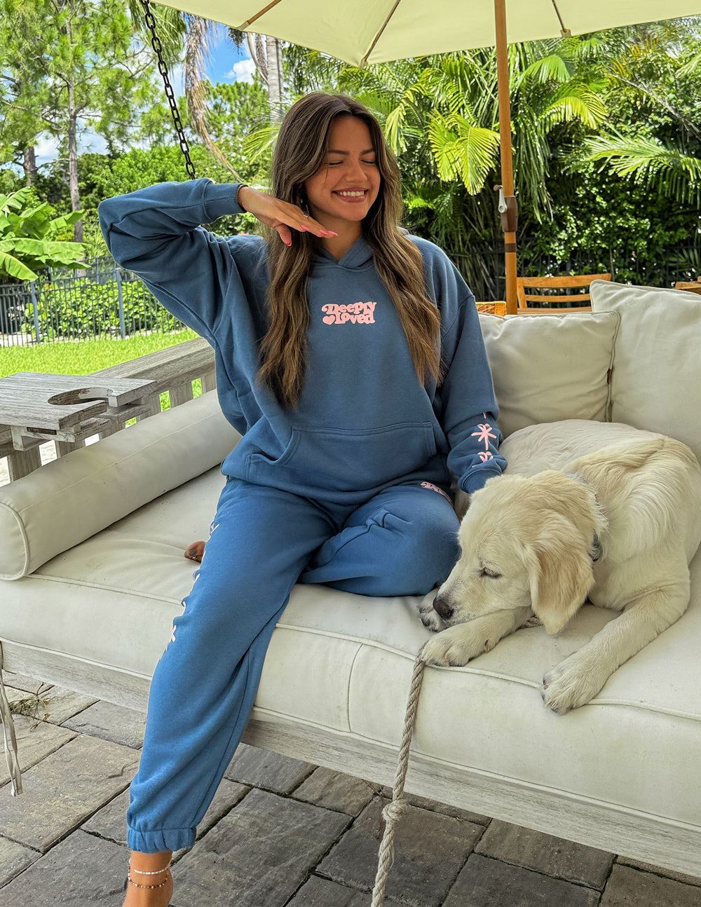 Blue unisex hoodie with hood, chest logo graphic, and starburst sleeve details