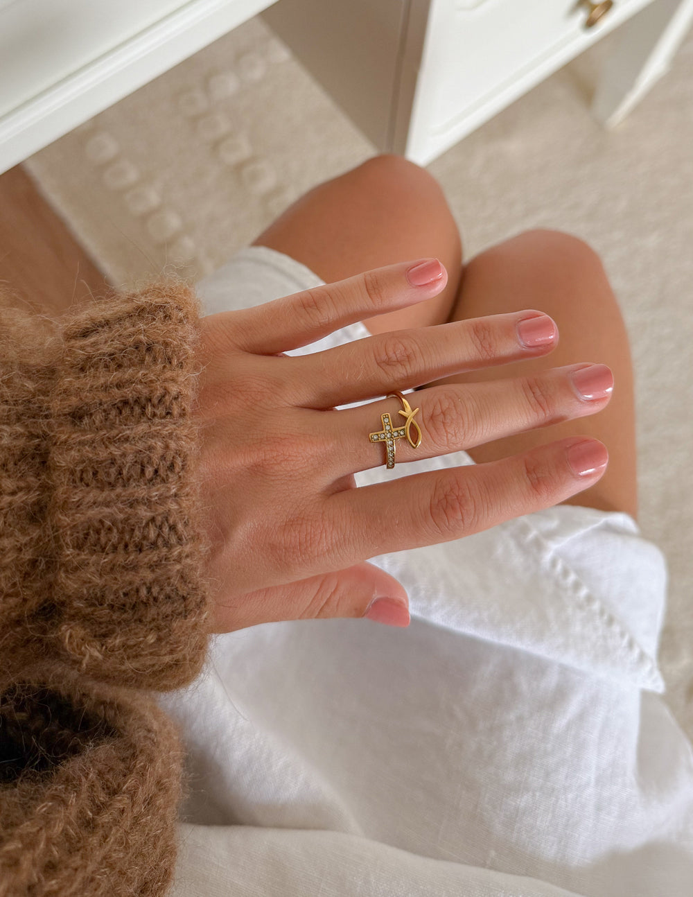 Gold-tone cross ring with clear stones on slim band, close-up