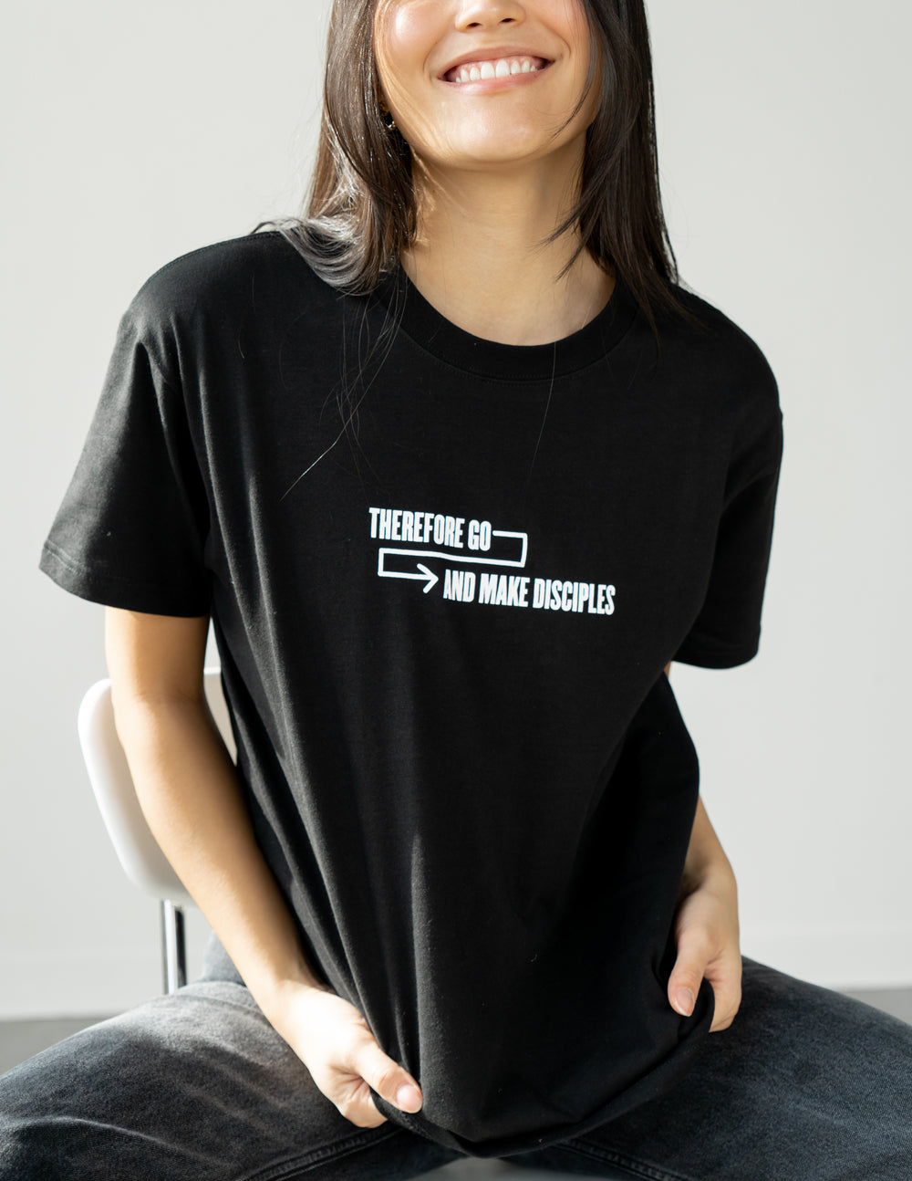 Unisex T-shirt, black, with small white arrow-and-text graphic at the chest