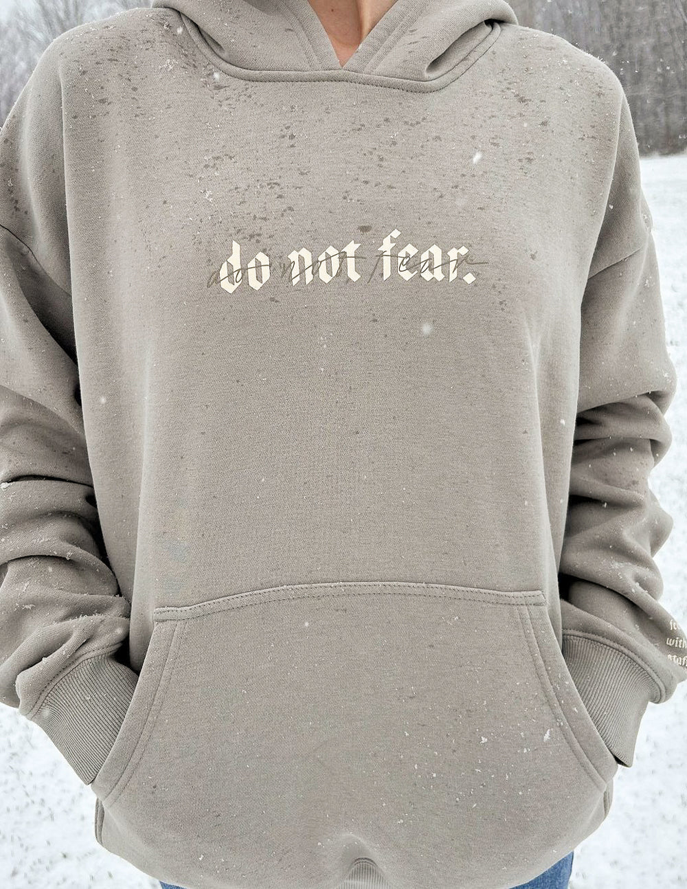 Grey unisex hoodie with “do not fear.” chest print and front pocket opening.