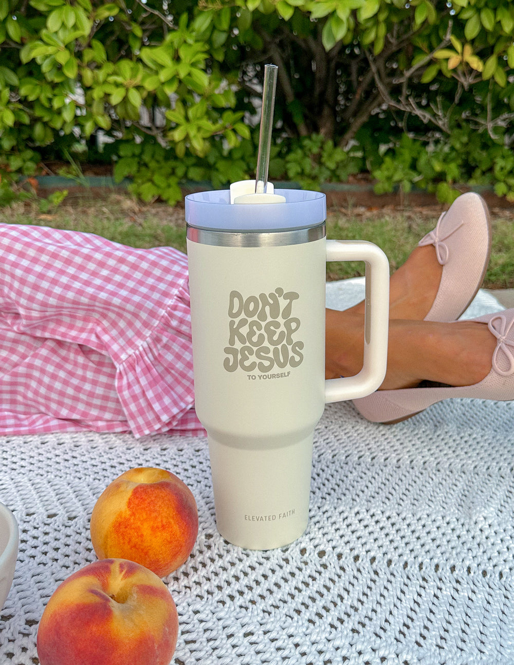 Cream tumbler with silver lid and straw, front quote and side handle