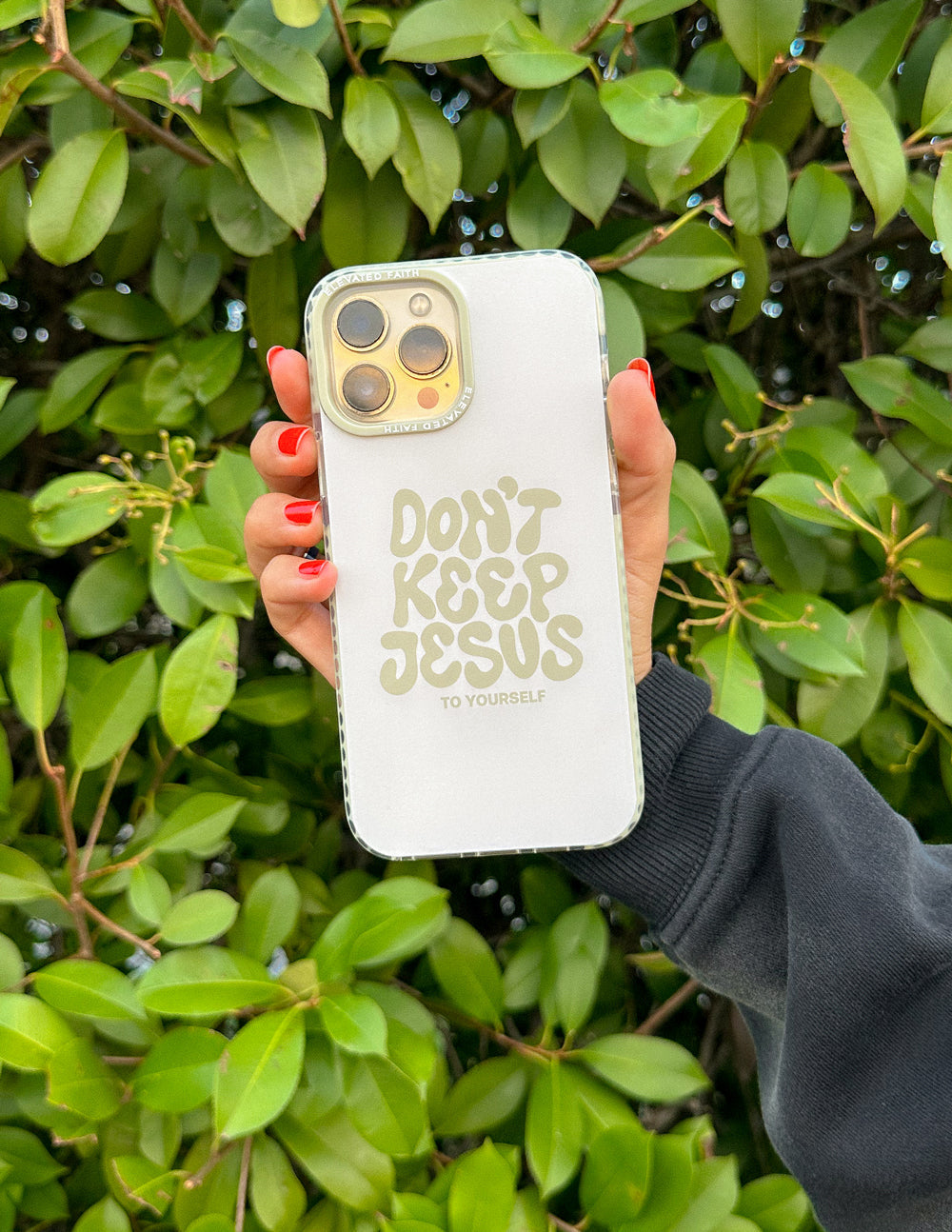 White phone case with "Don't Keep Jesus to Yourself" text, held up with camera cutouts