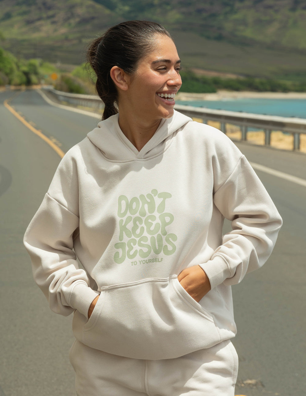 Cream unisex hoodie with green "DON'T KEEP JESUS" graphic on front, hood with drawstring