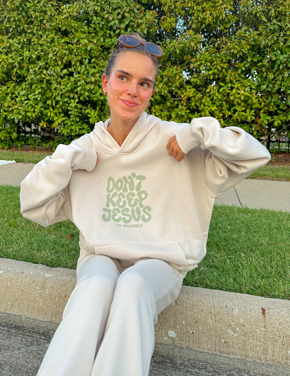 Cream unisex hoodie with green "DON'T KEEP JESUS" front graphic, hood and front pocket