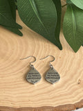 Silver dangle earrings with engraved “With God all things are possible” text.
