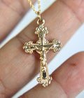 14k gold crucifix pendant on a chain, front view with ornate detailing.