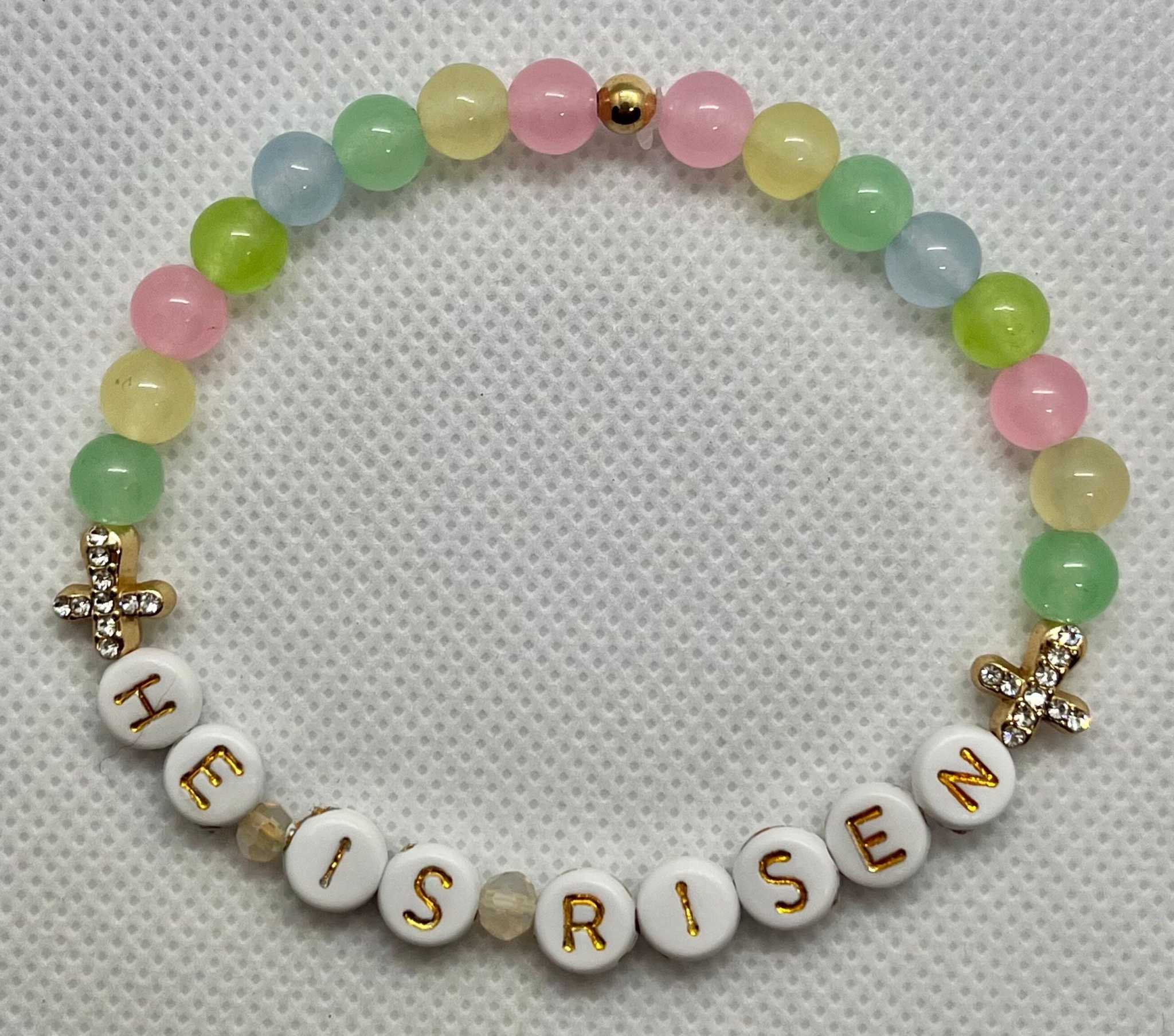 Pastel bead bracelet with “HE IS RISEN” letters and gold cross charms