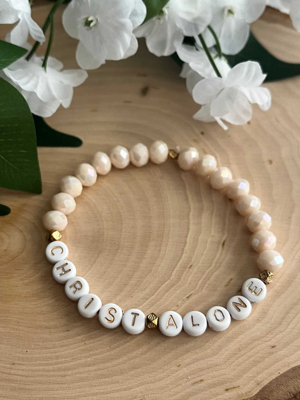 Cream pearl-style bead bracelet with letter beads spelling "CHRIST ALONE" and gold accents