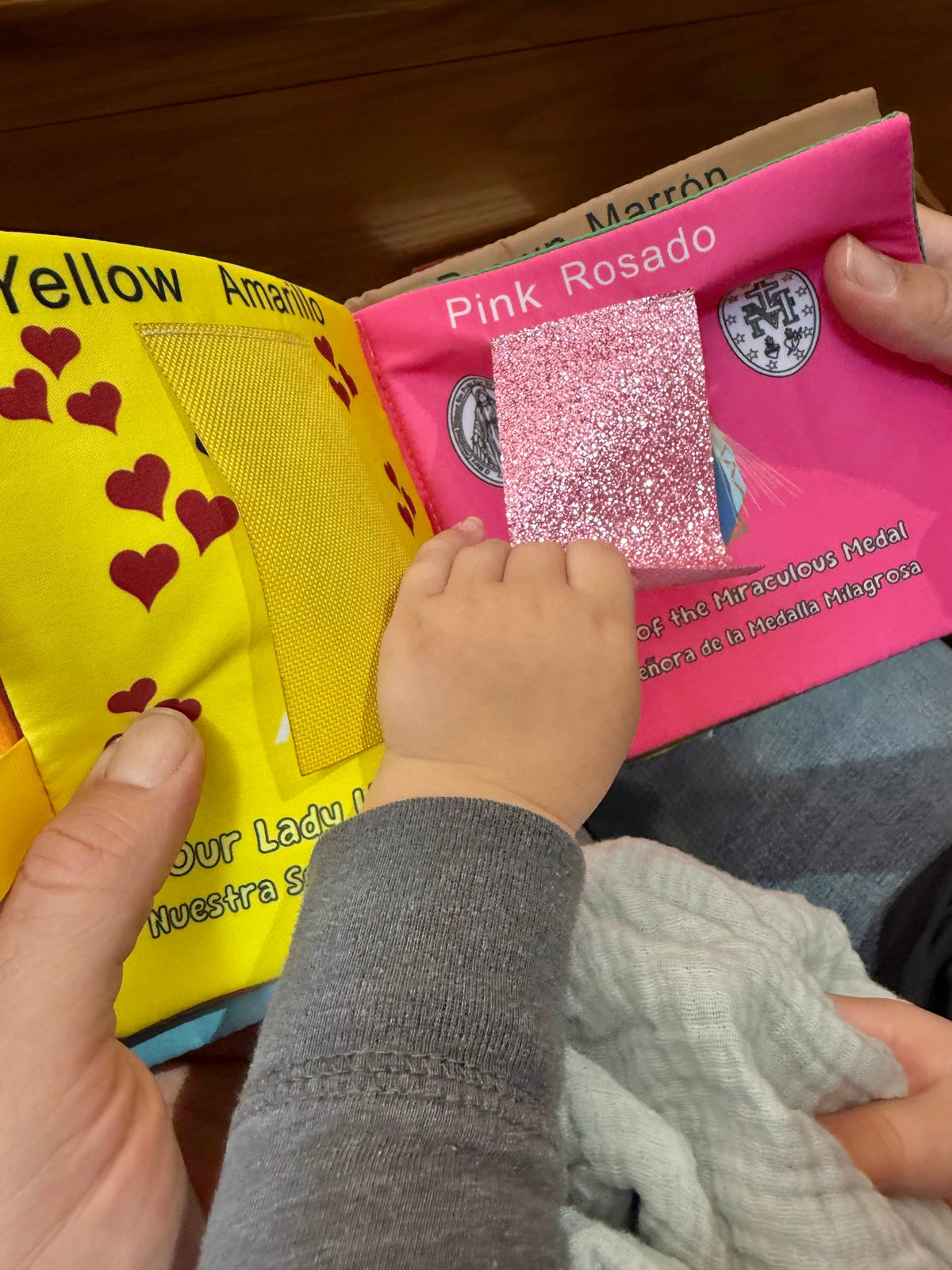 Close-up of glitter pink and yellow fabric pages on a Mary colors book.