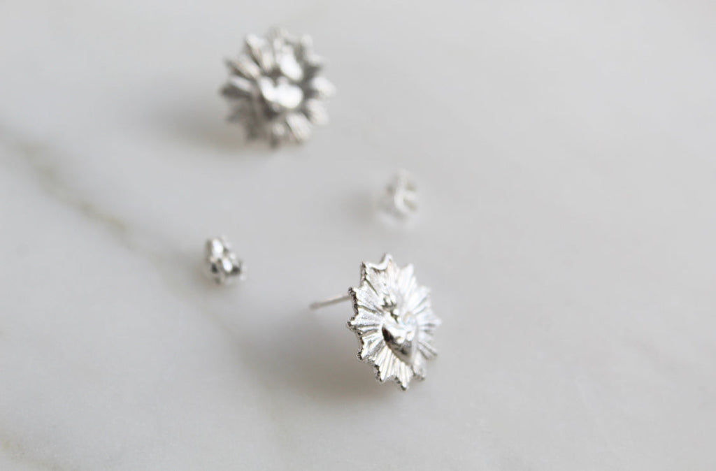 Silver-tone sacred heart stud earrings with small flowered heart details