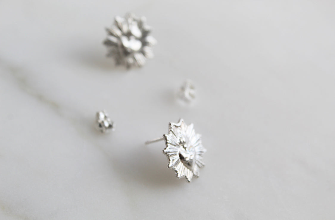 Silver-tone sacred heart stud earrings with small flowered heart details