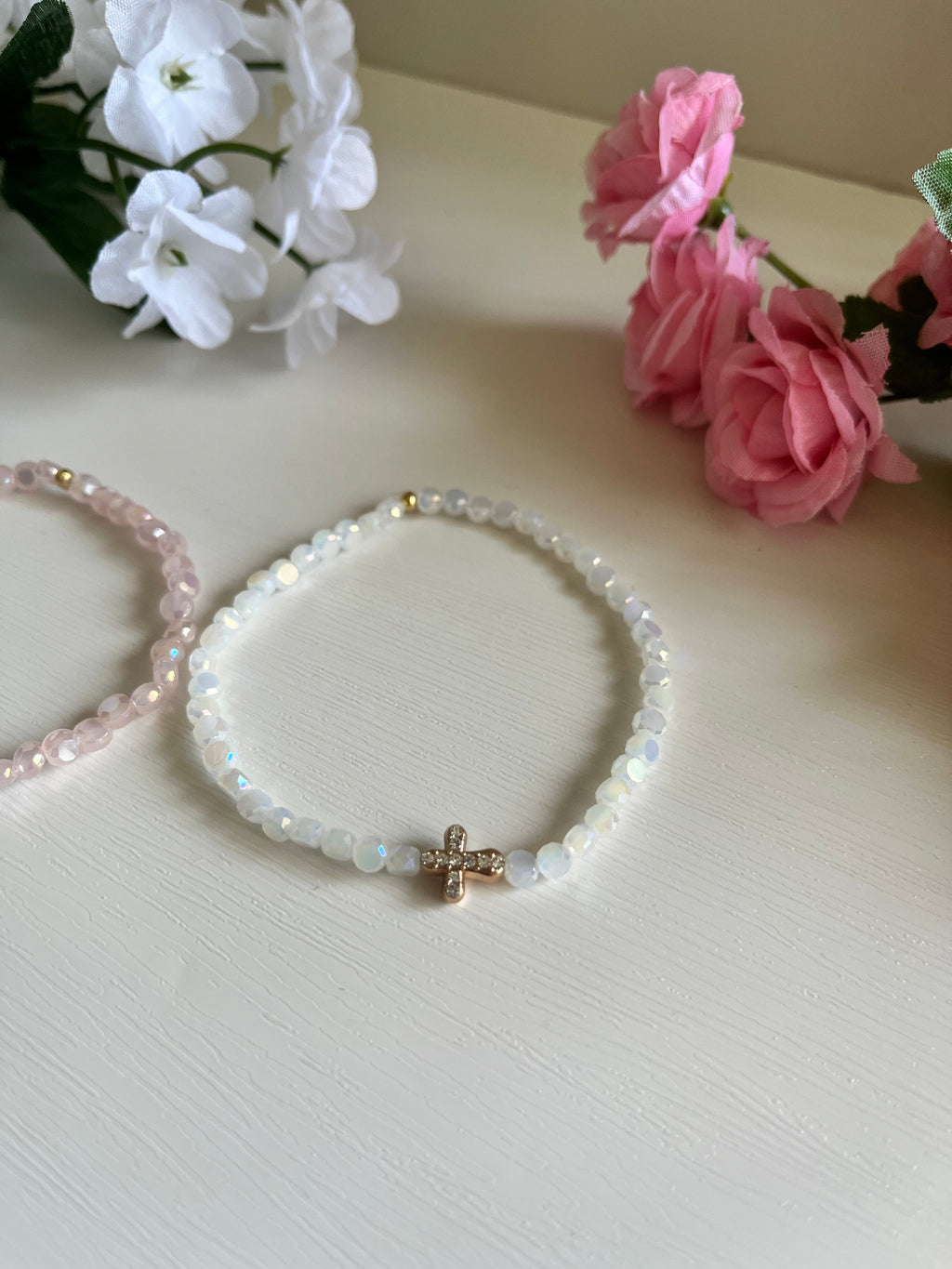 White beaded bracelet with gold cross charm