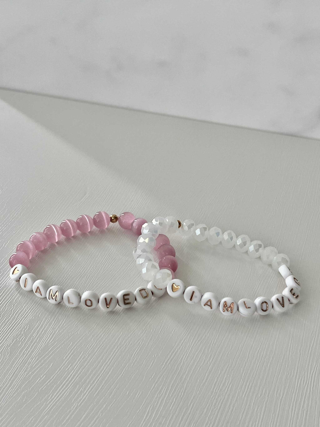 Pink and white beaded bracelet with 'I AM LOVED' letter beads and crystal accents