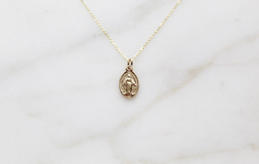 14k gold miraculous medal necklace with oval pendant on a delicate chain