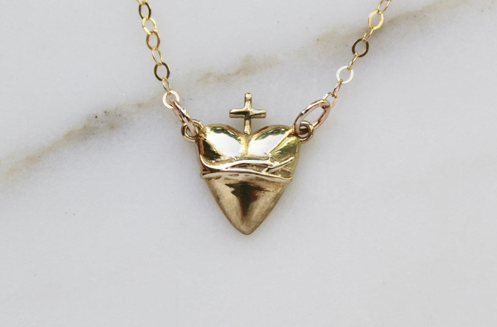 Gold-tone heart pendant necklace with crown top and small cross