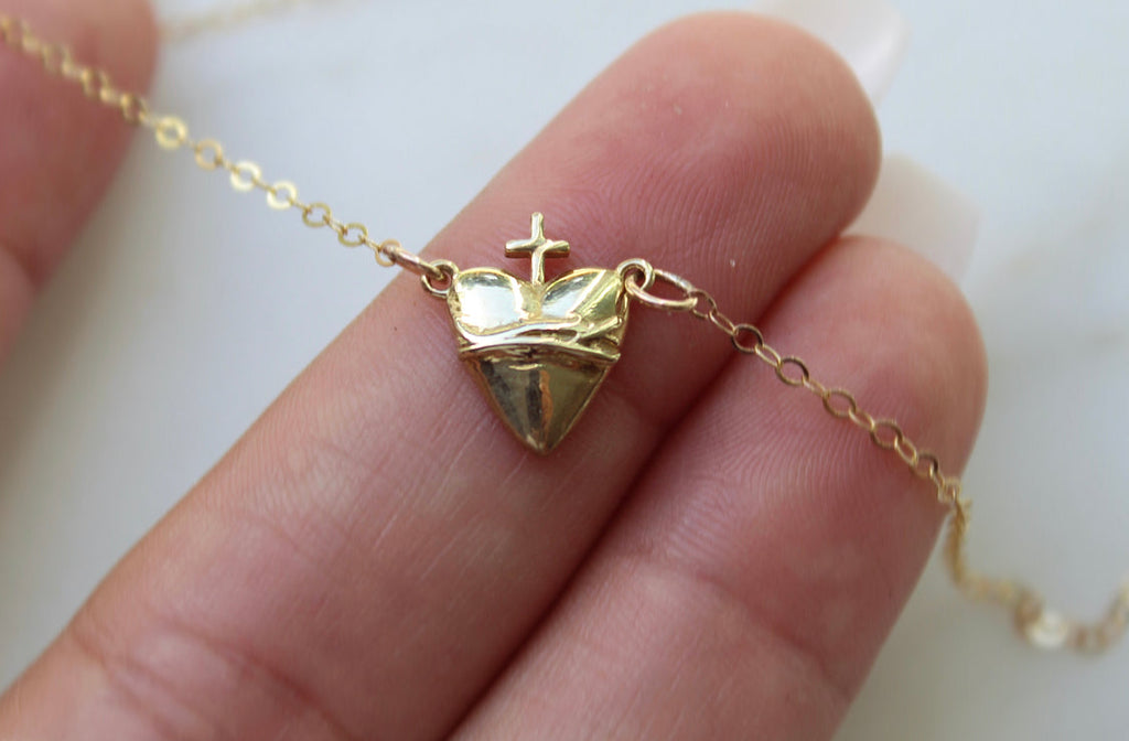 Gold-tone heart-shaped pendant necklace with crown and cross on chain