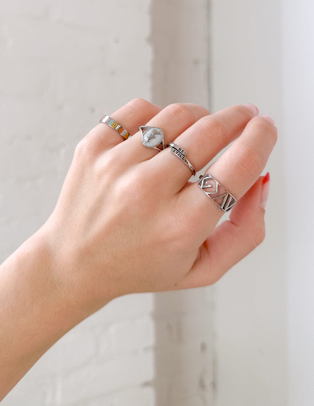 Silver signet ring with wildflower face on worn hand