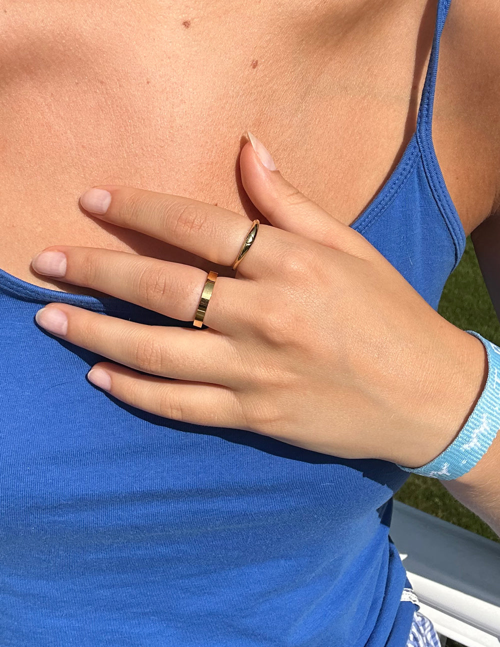 Gold flat band ring worn on a finger