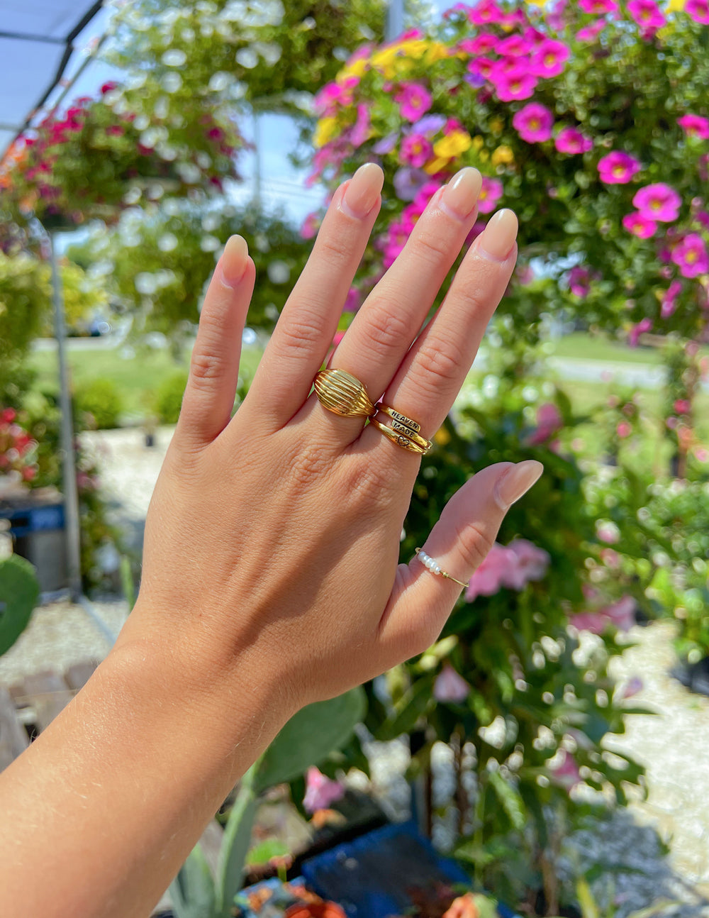 Gold-tone ribbed band ring on finger