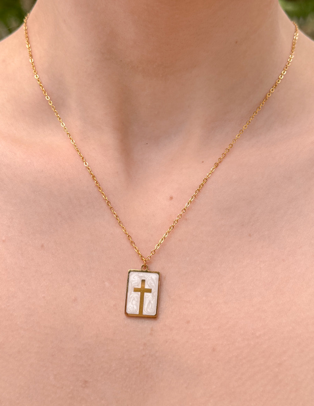 Square enamel cross pendant necklace on a thin gold chain, white enamel with dark cross