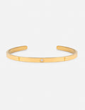 Gold-tone cuff bracelet with small gemstone accents and slim engraved links