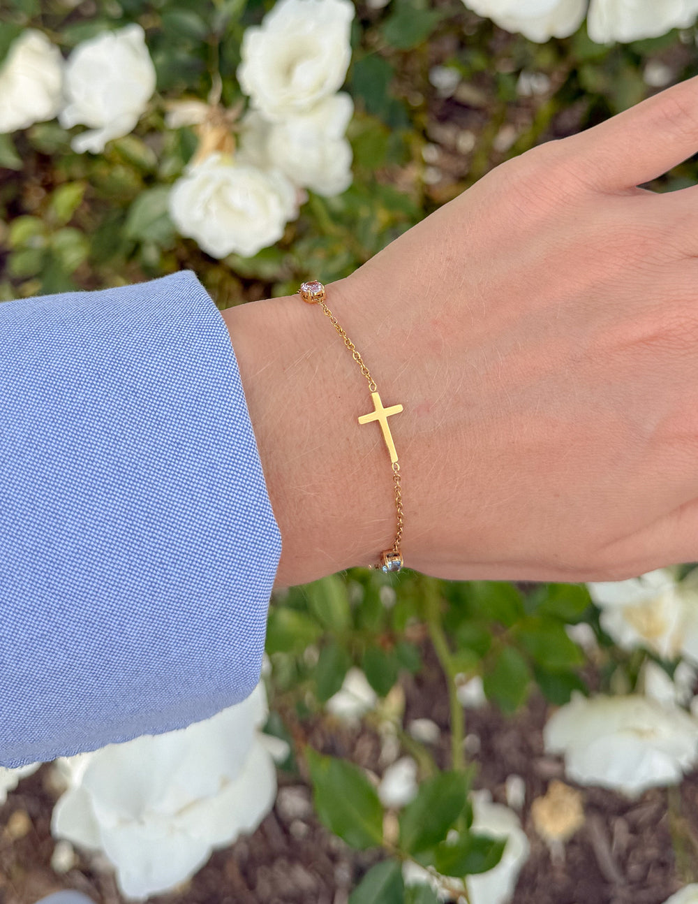 Gold link bracelet with cross charm and multicolor beads on wrist
